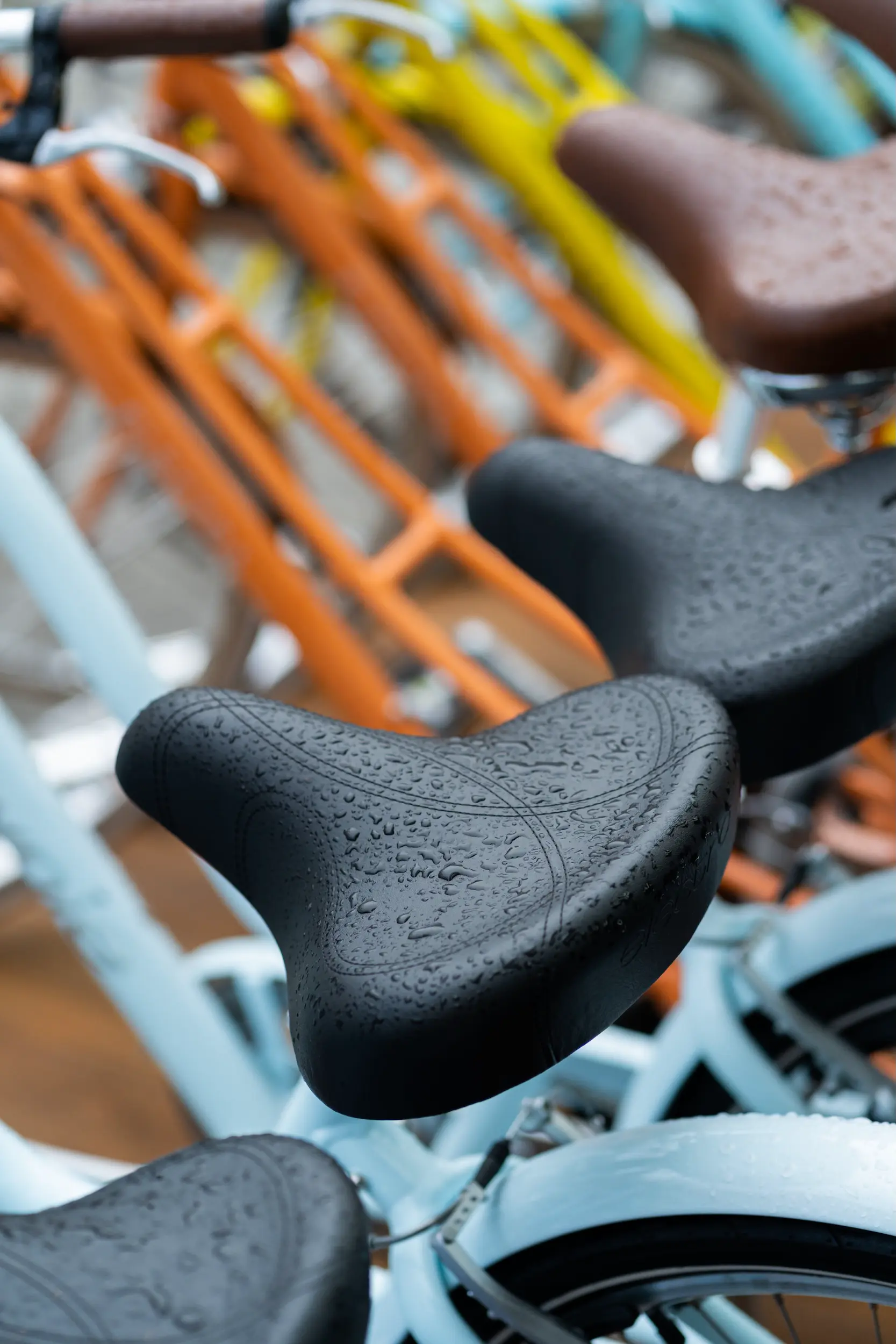 Nasse Fahrradsättel auf neuen bunten Fahrrädern